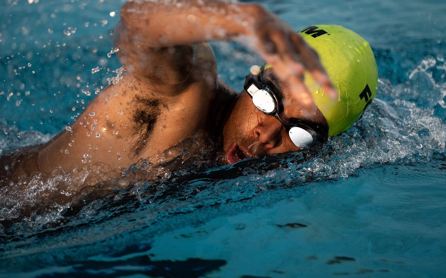 Man swimming front crawl with swim tracker in his goggles