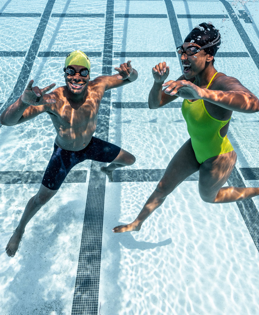 Two swimmers underwater with smart swim goggles