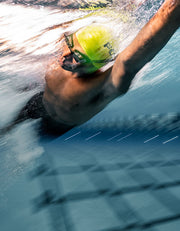 Man doing front crawl with a swimming heart rate monitor in his goggles